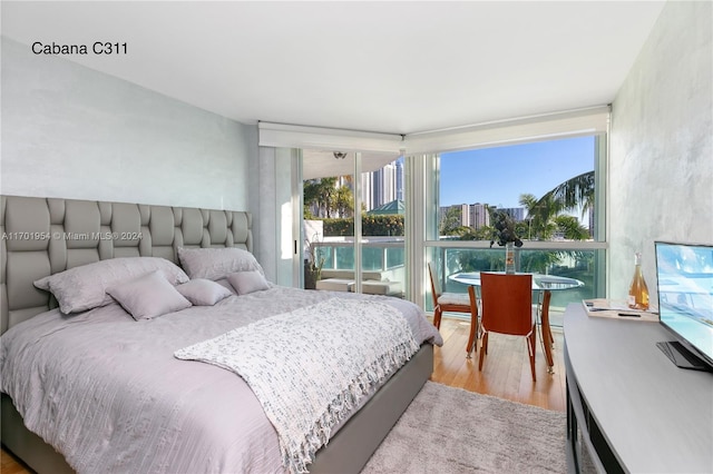 bedroom featuring multiple windows and light hardwood / wood-style flooring