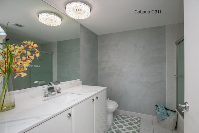 bathroom featuring vanity, tile patterned flooring, toilet, walk in shower, and a notable chandelier