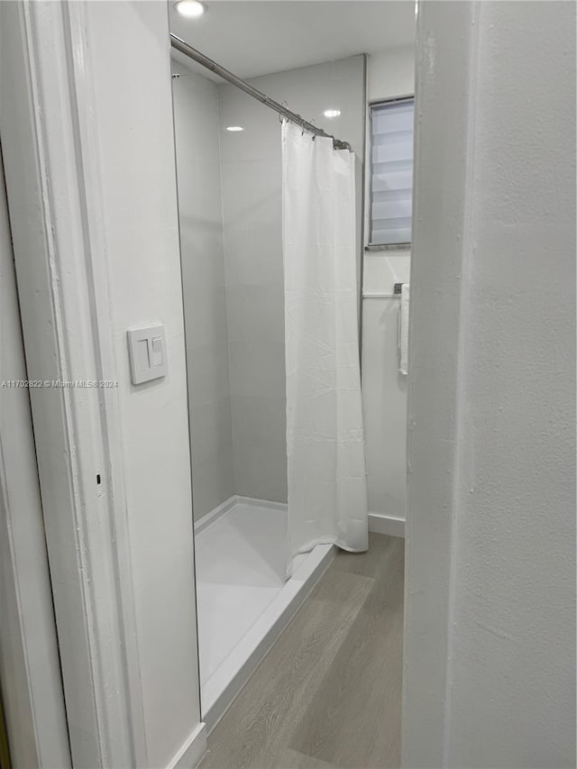 bathroom featuring hardwood / wood-style floors and walk in shower