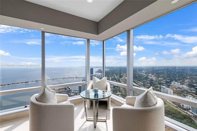 sunroom featuring a water view