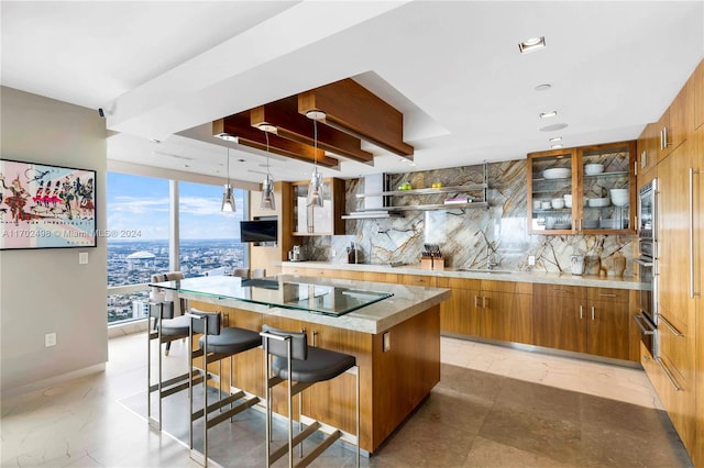 kitchen featuring decorative backsplash, a kitchen breakfast bar, sink, a kitchen island, and hanging light fixtures