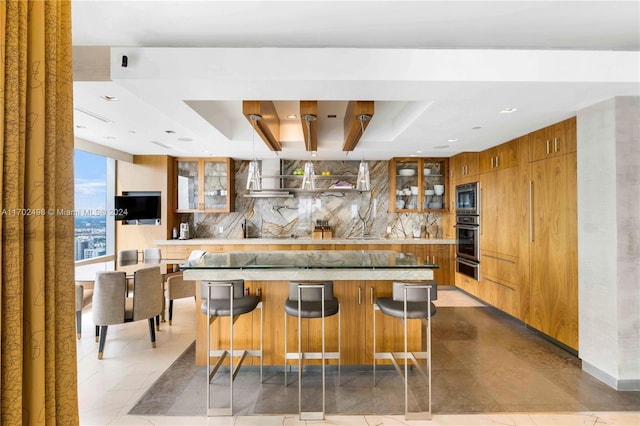 kitchen with decorative backsplash, a kitchen breakfast bar, appliances with stainless steel finishes, and a tray ceiling