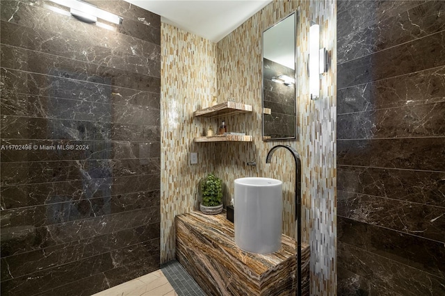 bathroom featuring tile patterned flooring and tile walls