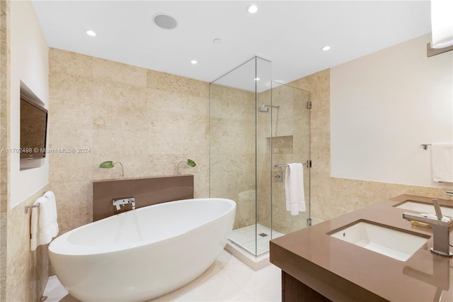 bathroom with tile patterned floors, vanity, plus walk in shower, and tile walls