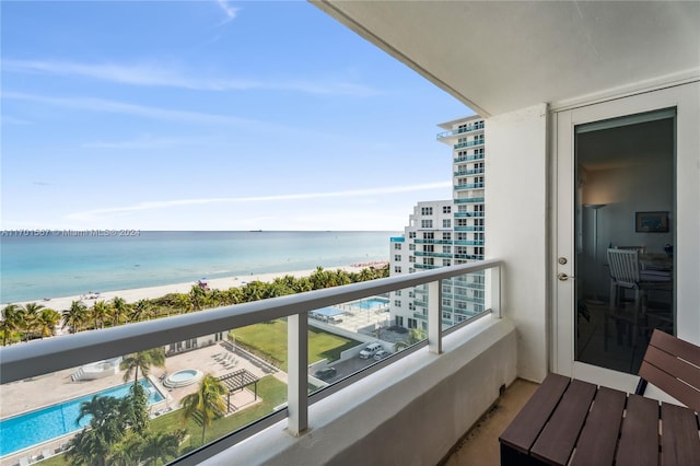 balcony featuring a beach view and a water view