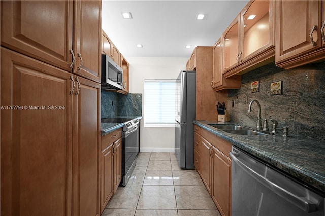 kitchen with decorative backsplash, sink, appliances with stainless steel finishes, and dark stone counters