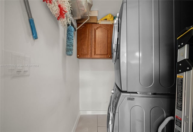 washroom with stacked washer and dryer and light tile patterned flooring