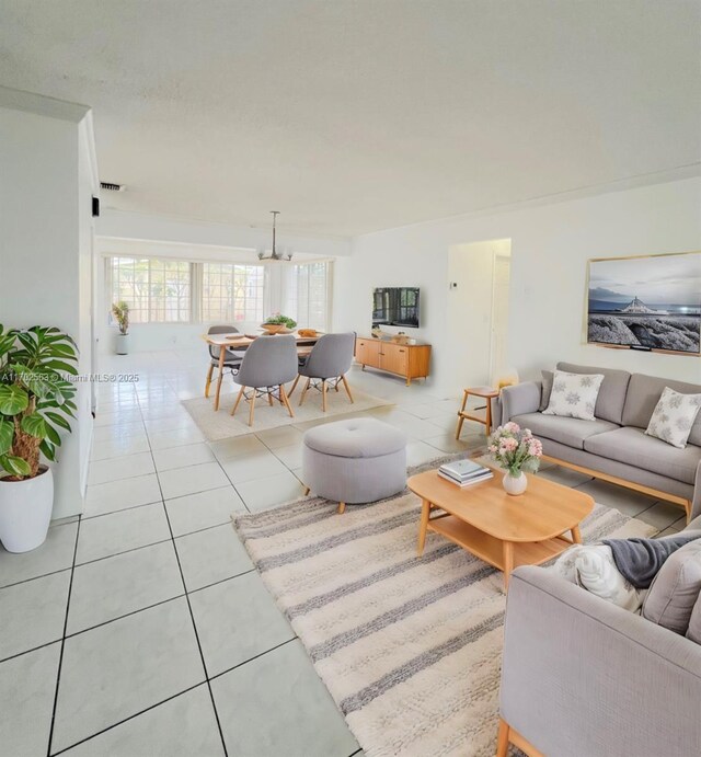 tiled living room with a notable chandelier