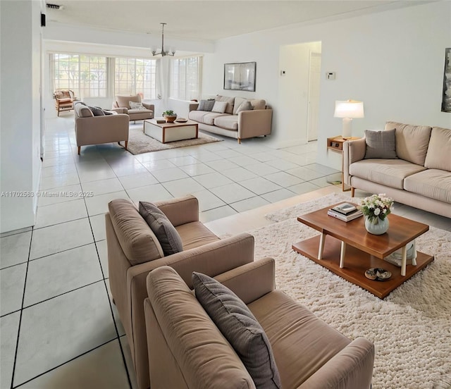 tiled living room with a notable chandelier