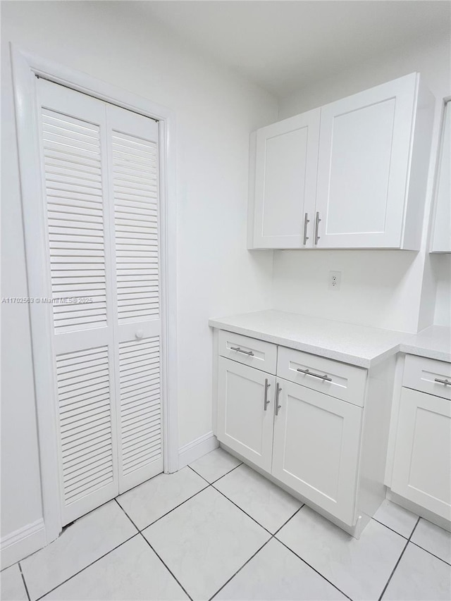 kitchen with light tile patterned flooring and white cabinets