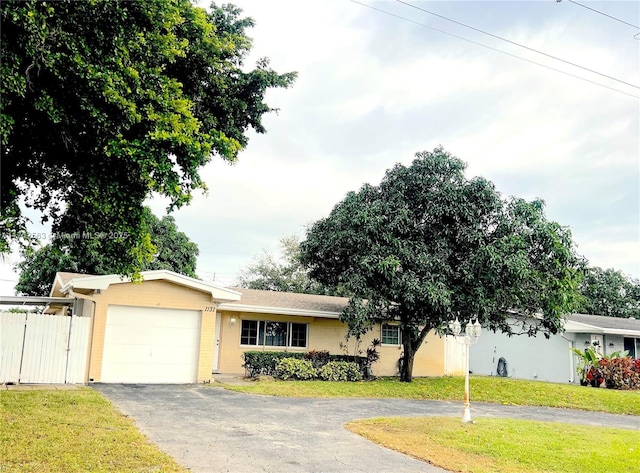 single story home featuring a garage and a front yard