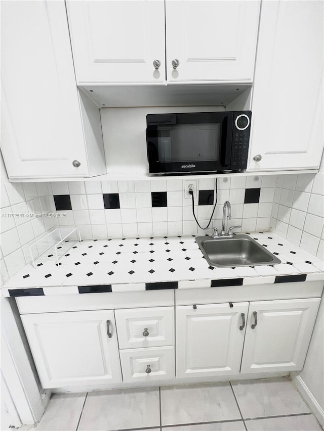 kitchen with sink, decorative backsplash, and white cabinets