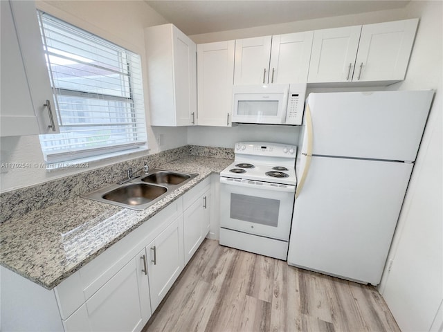 kitchen featuring white cabinetry, light stone countertops, sink, light hardwood / wood-style flooring, and white appliances