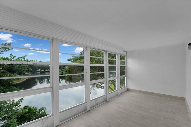 unfurnished sunroom featuring a water view