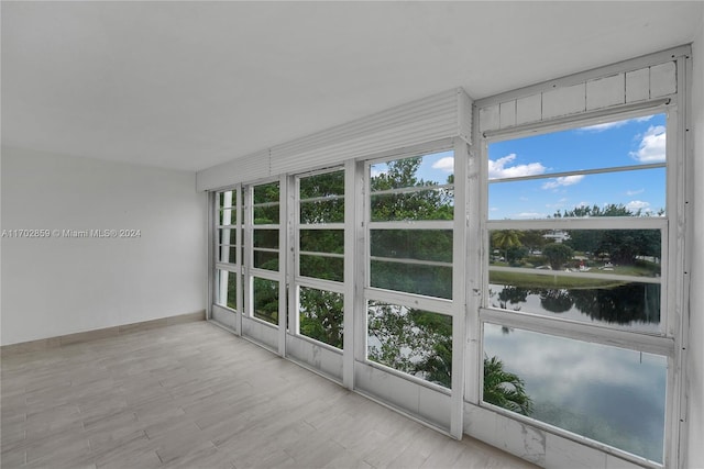 unfurnished sunroom with a water view and a healthy amount of sunlight