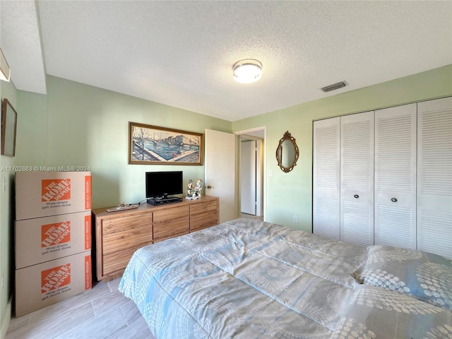 bedroom with a textured ceiling and a closet