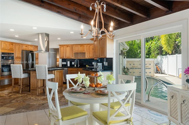 dining room with vaulted ceiling with beams, an inviting chandelier, and sink