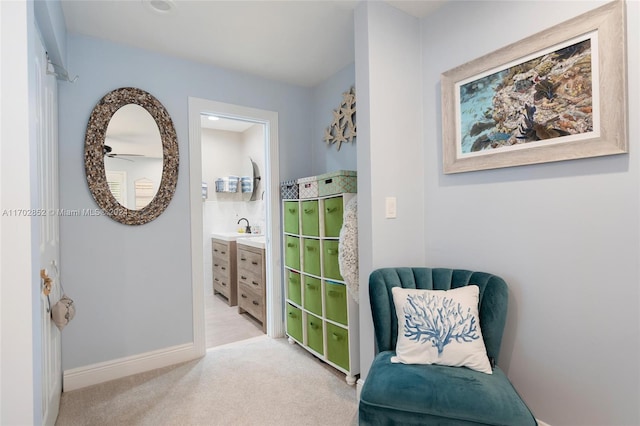 living area featuring light carpet and sink