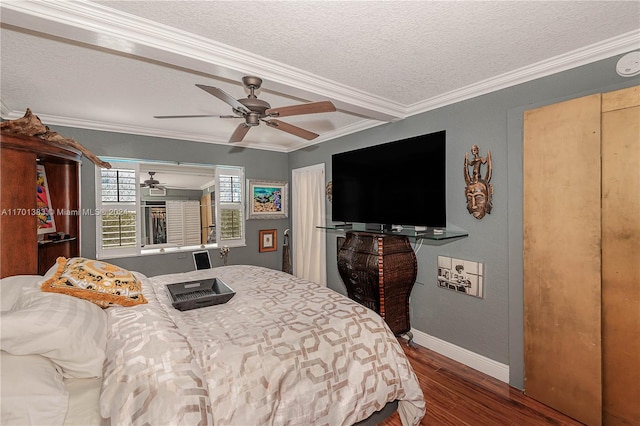 bedroom with hardwood / wood-style floors, a textured ceiling, ceiling fan, and ornamental molding