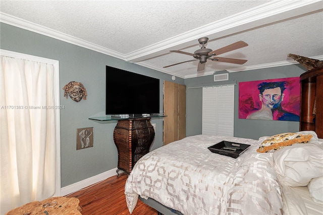 bedroom featuring hardwood / wood-style flooring, ceiling fan, crown molding, and a textured ceiling