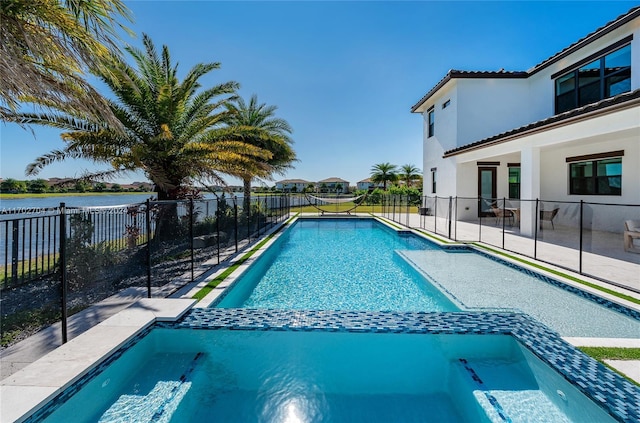 view of pool featuring a water view and an in ground hot tub