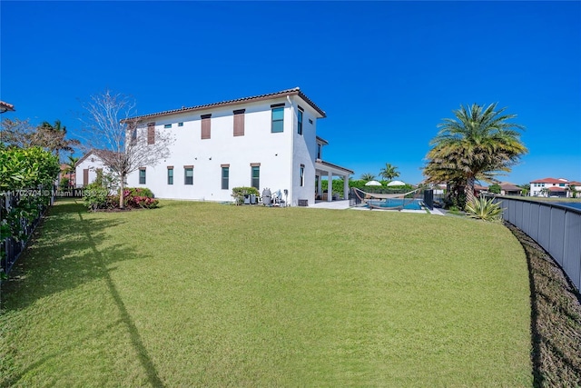 rear view of house featuring a pool, a yard, and a patio