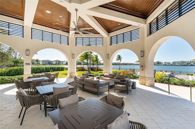 view of patio / terrace with ceiling fan, a water view, and an outdoor hangout area