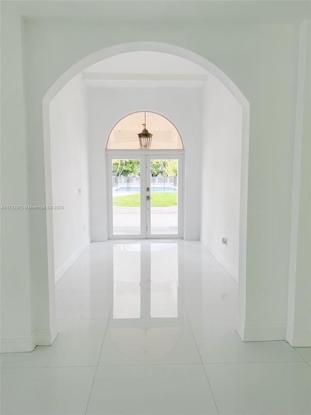 empty room featuring light tile patterned floors and french doors