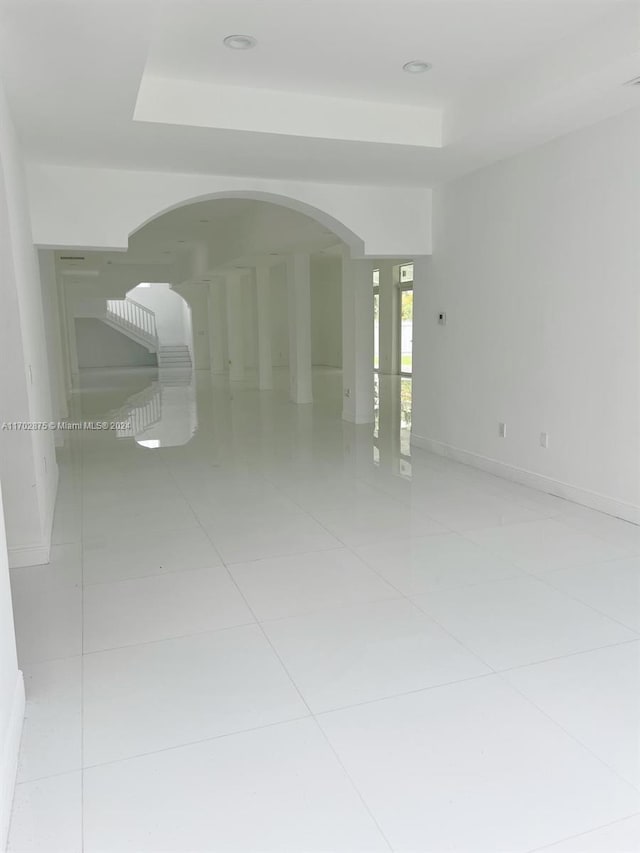 spare room featuring light tile patterned floors and a tray ceiling