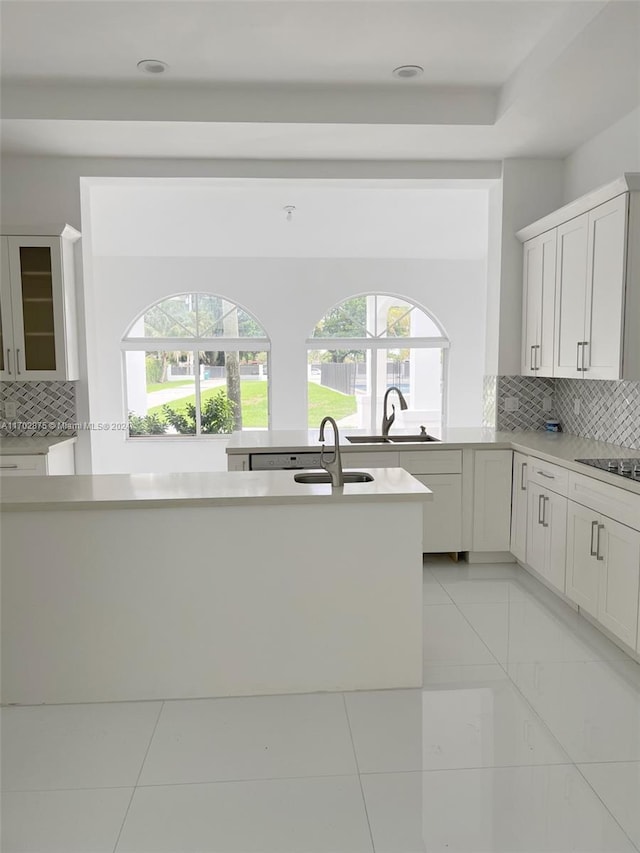 kitchen featuring white cabinets, plenty of natural light, sink, and backsplash