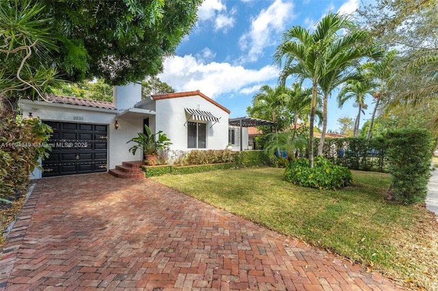 mediterranean / spanish house featuring a front yard and a garage