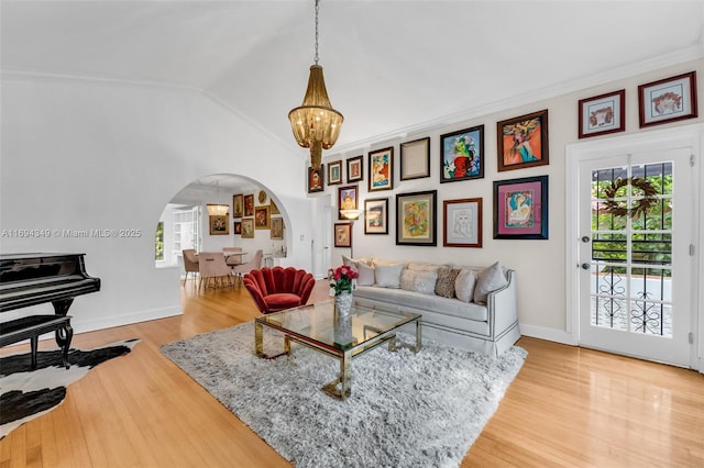 living room with a notable chandelier, lofted ceiling, crown molding, and a wealth of natural light