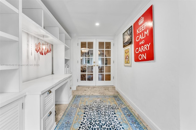 mudroom with built in shelves, french doors, and a chandelier