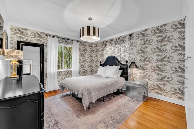 bedroom with ornamental molding and hardwood / wood-style flooring