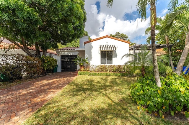 view of front of house with a front yard and a garage