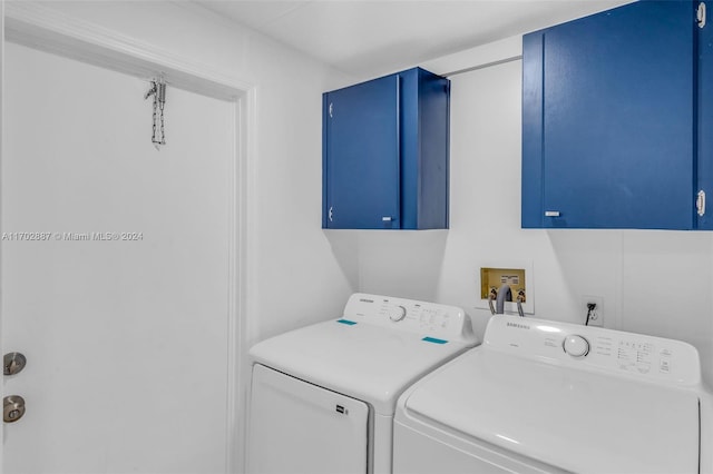 laundry room featuring washing machine and clothes dryer and cabinets