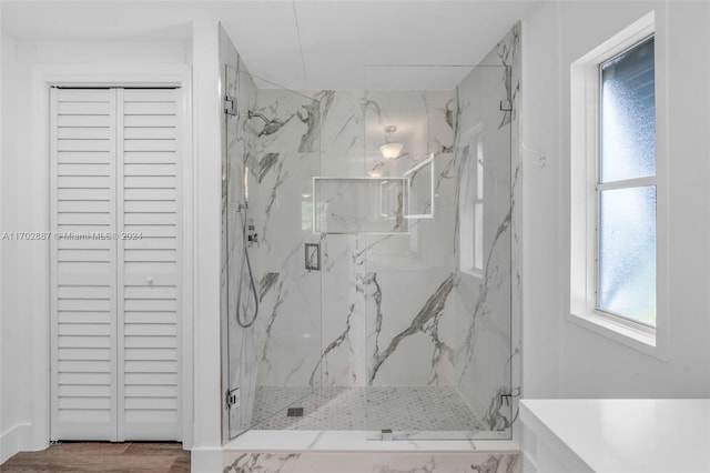 bathroom with a shower with door and wood-type flooring