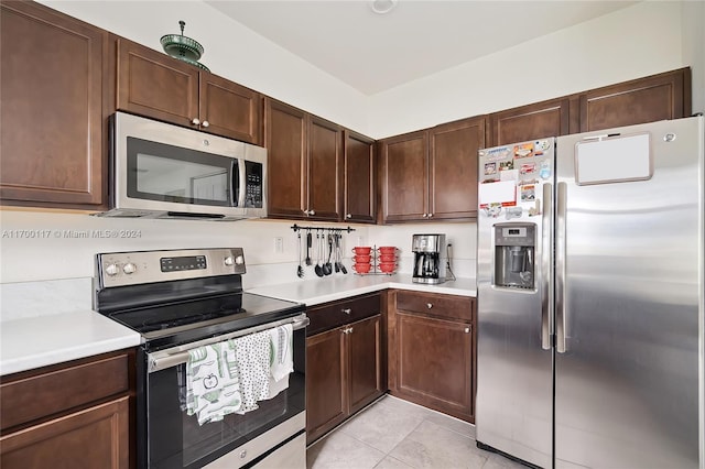 kitchen featuring light tile patterned floors, dark brown cabinetry, and appliances with stainless steel finishes