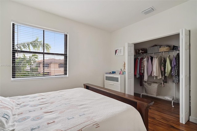 bedroom featuring dark hardwood / wood-style flooring, a closet, and multiple windows