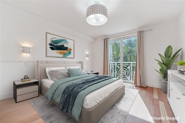 bedroom with access to exterior and light hardwood / wood-style flooring