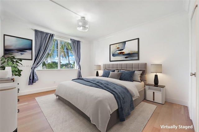 bedroom featuring light hardwood / wood-style floors and ornamental molding