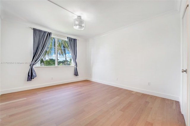 empty room with light hardwood / wood-style floors and ornamental molding