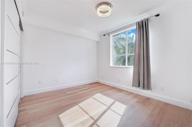 unfurnished room featuring light wood-type flooring and ornamental molding