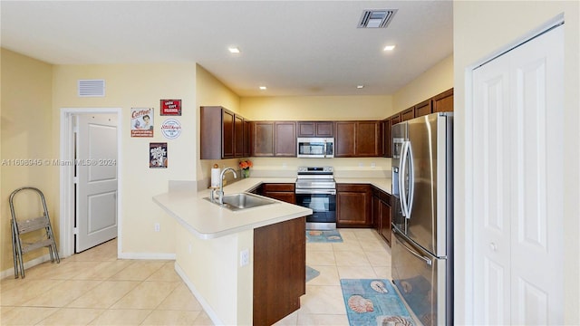 kitchen featuring kitchen peninsula, sink, light tile patterned floors, and appliances with stainless steel finishes