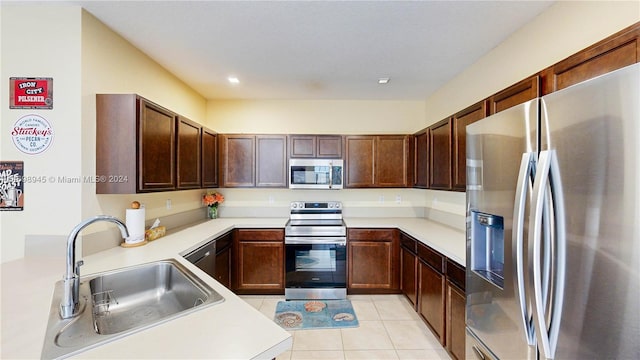 kitchen featuring light tile patterned flooring, appliances with stainless steel finishes, and sink