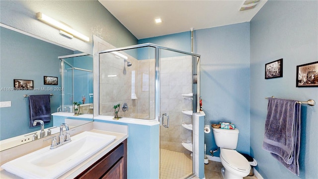 bathroom with tile patterned flooring, vanity, a shower with shower door, and toilet