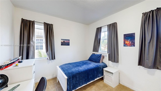 bedroom featuring light carpet and a textured ceiling