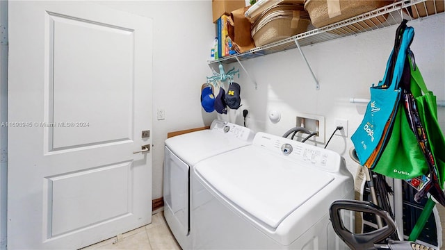 laundry area featuring washer and clothes dryer and light tile patterned flooring