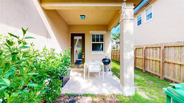 view of exterior entry with a patio