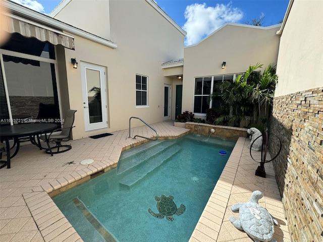 view of pool with pool water feature and a patio